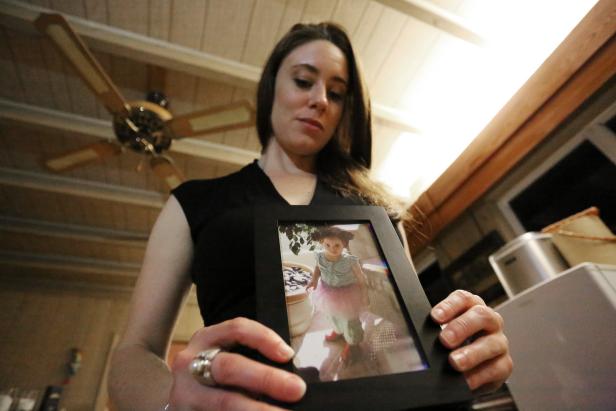 In this Feb. 13, 2017 photo, Casey Anthony poses with a photo of her daughter Caylee during an interview in her West Palm Beach, Fla., home. Anthony, 30, opens up for the first time on-the-record about the death of her daughter in 2008. (AP Photo/Joshua Replogle)