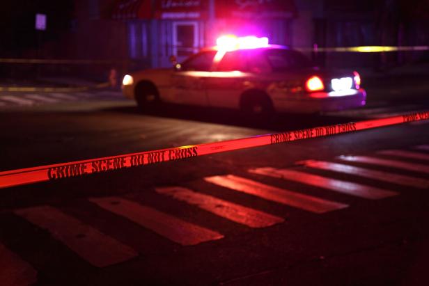 Police car and crime-scene tape on a city street [iStock Photo]