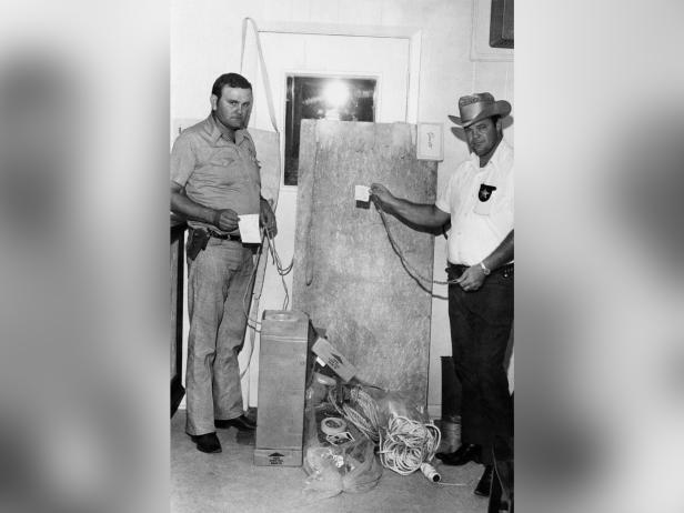 San Augustine County Sheriff deputies Robert McCroskey and Charles Martin display torture implements found inside and under a cabin owned by the parents of Dean Corll [AP Photo]