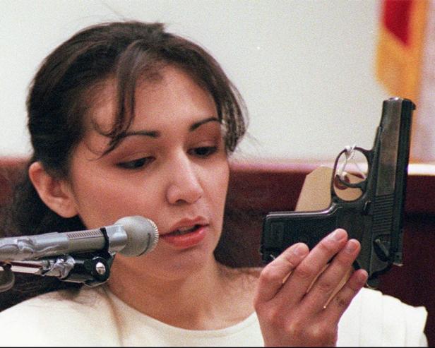Diane Zamora holds the gun used to kill Adrianne Jones during testimony Wednesday, Feb. 11, 1998, in the capital murder trial at the Tarrant County Court House in Fort Worth, Texas. Zamora, the former Naval midshipman accused of ordering her ex-fiance to kill a one-time lover and helping him do it, sat blank-faced as prosecutors read his confession, then continued to deny her involvement. (AP Photo/Jill Johnson, Pool)