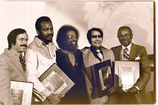 Reverend Jim Jones of Peoples Temple (2nd from right) is one of the recipients who is given a Martin Luther King, Jr. Humanitarian Award at Glide Memorial Church by Reverend Cecil Williams (3rd from right) in San Francisco. From left is Bob Gnaizda of Public Advocates, Inc.; Mack Lyons of United Farm Workers Union; and at far right is Dr. Carlton B. Goodlett, publisher of the San Francisco Sun Reporter