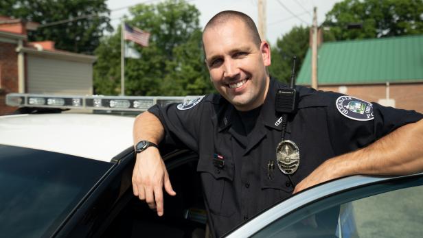 Officer Josh Hilling with police squad car [Investigation Discovery]