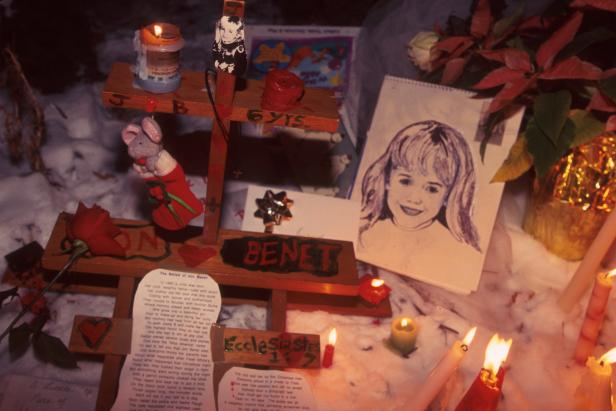 People light candles at the murder site of six-year-old JonBenèt Ramsey in Boulder, Colorado, December 1997 [Karl Gehring/Liaison via Getty Images]
