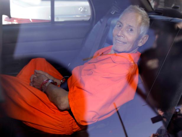 Robert Durst smiles as he is transported from Orleans Parish Criminal District Court to the Orleans Parish Prison after his arraignment on murder charges in New Orleans [AP Photo/Gerald Herbert, File]