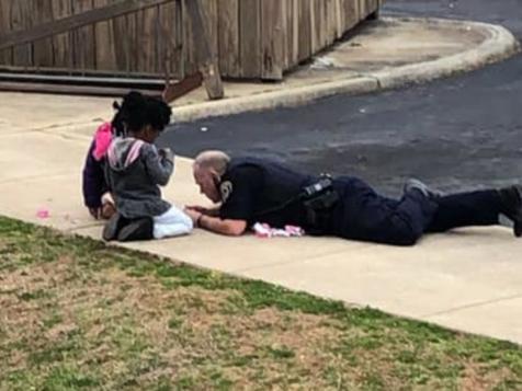 'Superhero' Cop Caught On Tape Playing Dolls With Nervous Kids During Gas Scare