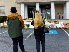 People view a makeshift memorial on Friday, March 19, 2021, in Atlanta. Robert Aaron Long, a white man, is accused of killing several people, most of whom were of Asian descent, at massage parlors in the Atlanta area. [AP Photo/Candice Choi]