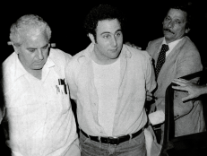 Police officials bring in handcuffed Son-of-Sam suspect David Berkowitz to side entrance of Police Headquarters. [Al Aaronson/NY Daily News via Getty Images]
