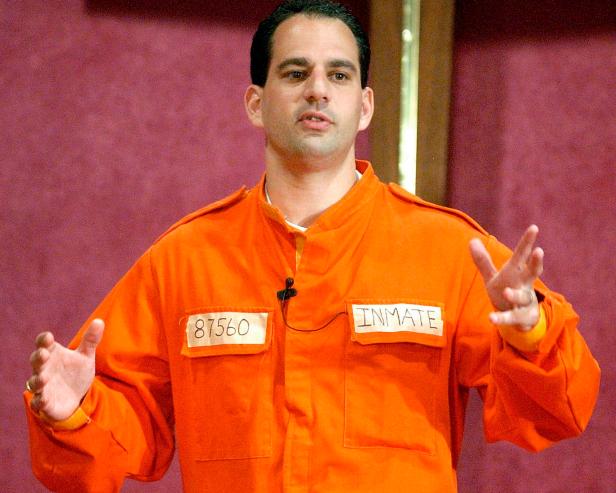 In this July 7, 2002 file photo, Barry Minkow, a convicted con artist and the co-founder of the for-profit Fraud Discovery Institute, wears a prison jumpsuit costume as he delivers a sermon on materialism at the Community Bible Church in San Diego. Minkow, who went from teenage millionaire to convicted con artist to professional fraud fighter and pastor, was convicted Wednesday, Jan. 22, 2014 of cheating his San Diego church congregation out of some $3 million.