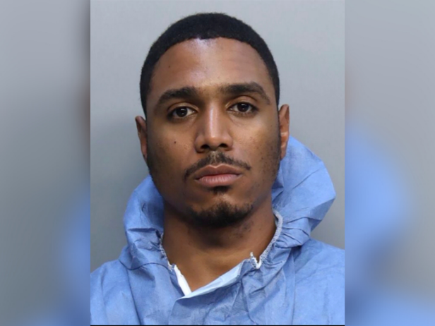 This mugshot provided by the Miami-Dade Corrections and Rehabilitation Department, shows Willy Suarez Maceo.  Maceo wears a light blue hoodie in front of a gray background.