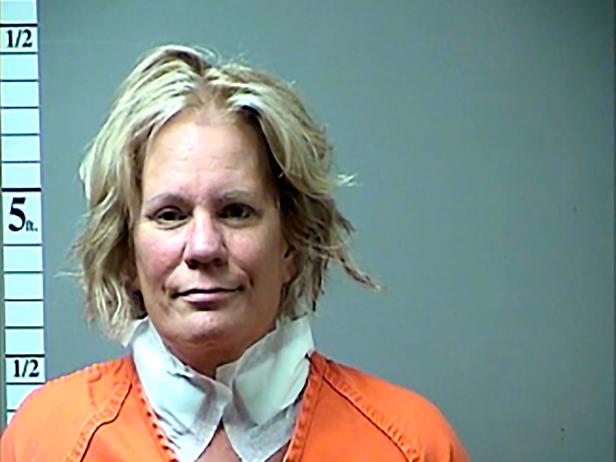 Pamela Hupp is shown in a mug shot wearing an orange prison top. She has blonde hair and is posed against a gray background.