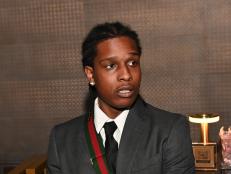 ASAP Rocky attends the launch of a liquor brand in Atlanta, Georgia on April 12, 2022. He wears a gray suit, with white shirt, and black tie.