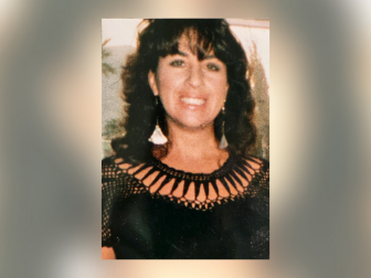 Cheryl “Cheri” Huss, pictured here smiling in a black shirt and dangly earrings, had been stabbed multiple times and bitten by her killer, who wasn't identified until 2022.