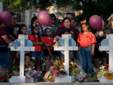 People gather at a memorial site to pay their respects for the victims killed in this week's elementary school shooting in Uvalde, Texas, Thursday, May 26, 2022. 