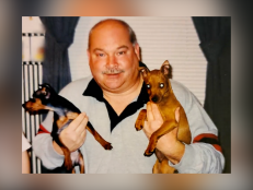 Odie Carrier, Jr., pictured here smiling holding two dogs, was found murdered in his apartment in November 2018.