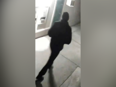 In this undated surveillance image released by the Stockton Police Department, a grainy still image of a “person of interest," dressed all in black and wearing a black cap, who appeared in videos from several of the homicide crime scenes in Stockton, California.