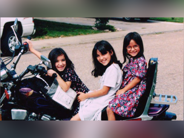 Jessica Lenahan's. three daughters (Rebecca, 10, Katheryn, 9, and Leslie, 7) smiling and posing on a bike. 