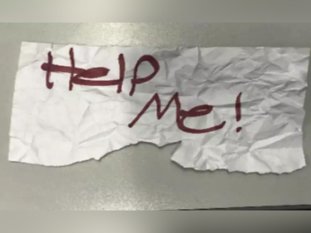 In this undated photo released by the U.S Department of Justice is a sign that says "Help Me!" used by a 13-year-old girl who was kidnapped in San Antonio, Texas. 